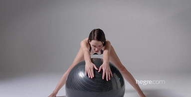 Ariel is playing with a yoga ball and shows her body