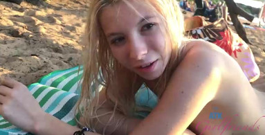 Petite blonde is topless and she relaxes at the beach