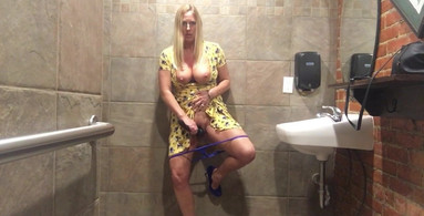 Horny MILF vibrates pussy in bar restroom!