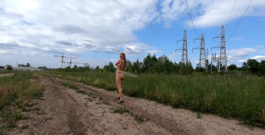Exhibitionist girl spins hoop in Russian field