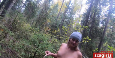 Naked girl looking for mushrooms in the forest